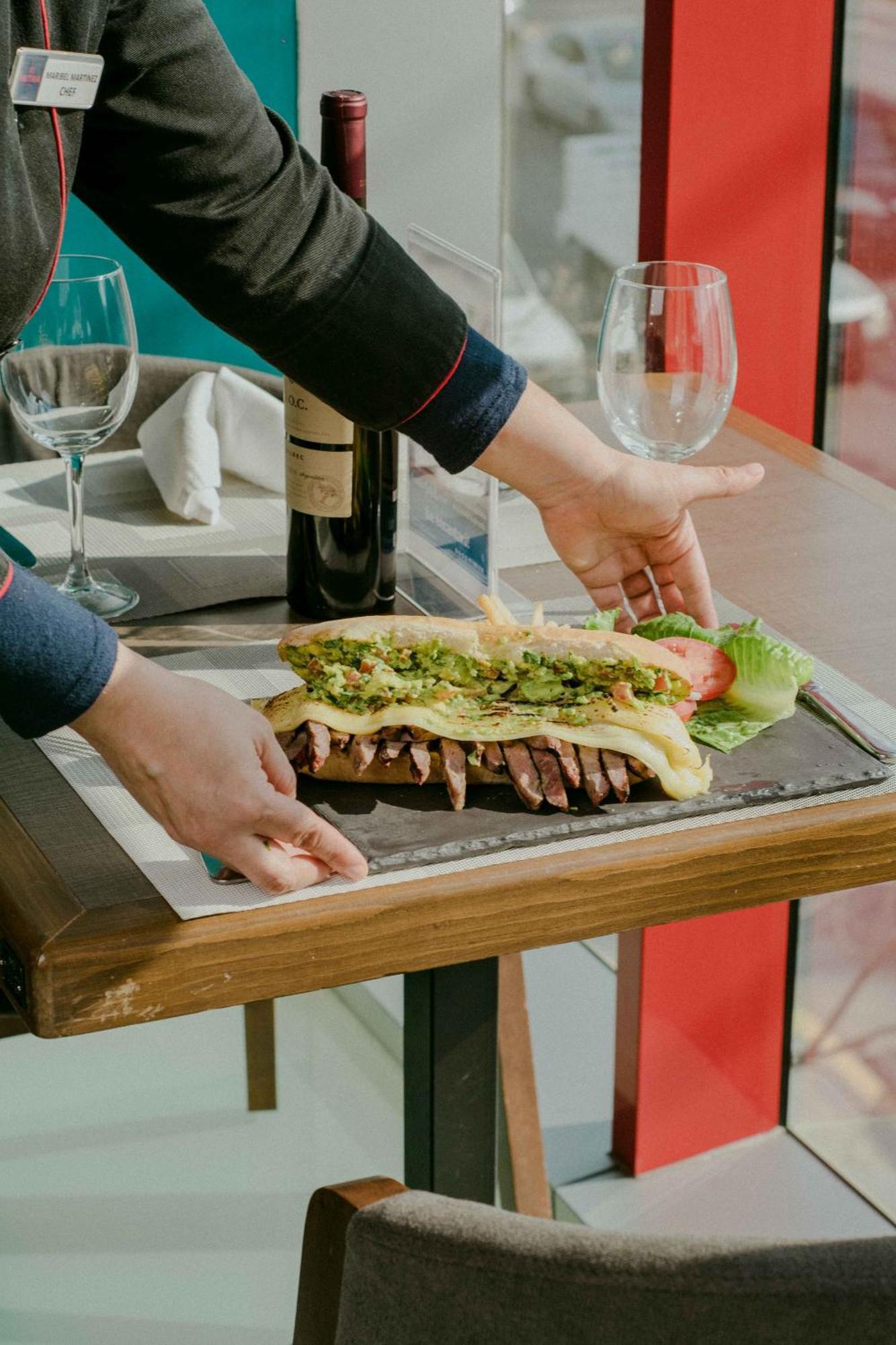 Metria Hotel レオン エクステリア 写真 A waiter serving a steak